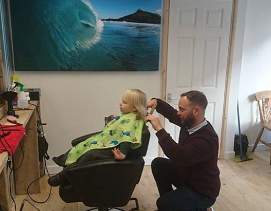 Bruno, cutting hair on the seaside in Porthleven, Cornwall